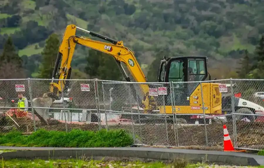 Excavator working on construction site for equipment and asset management software